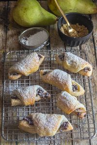 puff pastry crescents on a wire rack dusted with powdered sugar