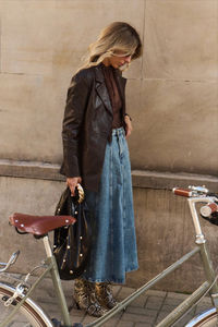 Live out your vintage dressing fantasy with this '70s-inspired look. It's made up of a dark brown blouse with tie detail, a flared denim midi skirt and a faux leather blazer. Add eye-catching details, like animal print leather boots and a large ladies' bag.  Get inspired by: @alicja_werniewicz  Add a touch of romance to your everyday style with boho chic-inspired pieces. Discover the collection now. | #ReservedForMe #newnow #ootd #fashion #boho #bohochic @reservedcom