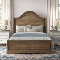 This standard bed infuses your main or guest bedroom with the warmth of a French country aesthetic. It is made of solid wood and features rustic planks running horizontally across the paneled headboard, which showcases a graceful arched shape framed by a carved edge. The wood is stained a caramel hue and has a purposefully distressed finish, along with knots and natural grain variation that add to the vintage, old-world look. This bed requires a box spring and mattress - either standard or adjus