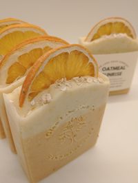 Oatmeal Sunrise is a citrus scented bar soap made with ground dried orange peel and oats, weighing approx. 4.75 to 5 oz's.  Each bar of Oatmeal Sunrise is adorned with half of a dried orange slice and dried chamomile blossoms. It has a subtle and sweet bouquet of mandarin orange, bergamot, and tangerine enhanced by hints of fresh peaches, strawberries, and raspberries on an undertone of white musk. The soothing ground orange peel and ground oats that are found throughout the body of the soap act