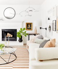 West Elm accents like the asymmetrical lamp and rattan candle holder help tie this clay-colored living room together.