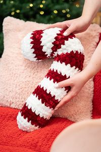 **This listing is for the Crochet Candy Cane Pillow Pattern PDF File and NOT the the finished item.** Get ready to cozy up with this super soft, velvet Crochet Candy Cane Pillow. It's a plush and luxurious addition to your holiday decor that you can make in under an hour! It's just like the expensive viral candy cane pillow you can find at the store, but better because you made it yourself! Add a touch of handmade holiday magic to your space with this quick and easy crochet project! Difficulty: