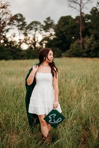 golden hour, senior session, east texas photographer, dfw photographer, brown hair, latina senior, green grass field, field photoshoot, cap and gown photos, gown only photos, cap only photos, senior western photos