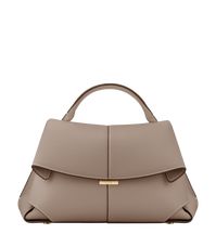 The "Mokki" model showcases the art of folding with its textured leather. The corners are cut to reveal smooth leather for a subtle interplay of textures. The bag’s interior is roomy and divided into compartments, all protected by a flap that features an engraved clasp. With its adjustable shoulder strap held in place by snap hooks, the model smoothly adapts to your movements.