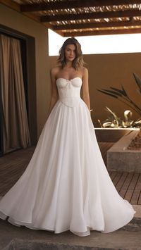 Make your wedding day extra special with this elegant Neoprene and Organza A-Line Wedding Dress. The corset top and laced back will ensure you look and feel your best on your special day. Features: • Corset top • Lacing and zipper back • Neoprene main material • Wrinkled organza details • Elegant A-line design