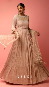 Onion pink tiered anarkali suit in georgette with zari, resham and sequins embroidered stripes all over and mesh design on the bodice.
The neckline is edged with kundan and mirror accents.
Crafted with ruffle sleeves, illusion neckline and side zip closure.
Topped with a matching net dupatta with embroidered diagonal stripes and mirror work on the border.
This piece comes with padding and cancan.