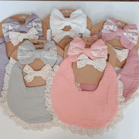 Lace Trim for the Win! I love these Muslin Bib and Bow Sets. 3 pieces with lovely vintage charm. Each Set Includes: Muslin Bib - Solid Color with cream lace trim. Plastic snap close with 2 size options so bib can grow with baby. Muslin and Lace bow on Stretchy Nylon Headband All Lace Bow on Stretchy Nylon Band