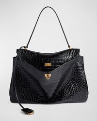 "Find BALENCIAGA Rodeo Large Croc-embossed Leather Shoulder Bag on Editorialist. Balenciaga \"Rode\" shoulder bag in crocembossed calfskin leather Shoulder strap, 9\" drop Detachable, adjustable crossbody strap, 22.4\" drop Removable leather key holder with two split rings Open top with turnlock closure Turn lock closure Wide front pocket 1 main compartment 1 inner zipped pocket 2 flat pockets at back side snaps Agedgold hardware Napa lambskin lining Feet protect bottom of the bag Approx. 11.8\"H x 15.7\"W x 5.1\"D Made in Italy"