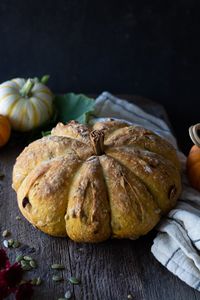 No-knead Pumpkin Harvest bread is mixed up in just a few minutes. Step-by-step instructions and photos make it simple to create a fun and rustic pumpkin-shaped loave of bread. Made with pumpkin pureé, dried fruit, pumpkin seeds, and sunflower seeds. An edible centerpiece for your Autumn table. #nokneadbread #pumpkinbread #pumpkin #crustybread #autumn #pumpkinspice