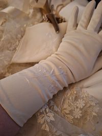 Gorgeous pair of genuine vintage cream coloured day gloves , they are a lovely mid length and have some pretty embroidered flowers across the front they are in excellent unworn condition This lovely pair of gloves would be a perfect addition to a vintage dress or even a wedding outfit Also great for an authentic film tv or stage prop Excellent condition with no damage or marks, They measure 13 inches from the tip of the middle finger to the top edge and 3 inches across the palm.  They are not  s