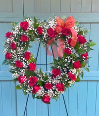 Heart-shaped funeral wreath with red roses