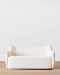 The broadset Alford Settee is upholstered with playful cream tones. Its silhouette is dense, while its form uses soft, curved lines to add a feminine, graceful quality to the piece. Inviting and approachable, the Alford is a lovely addition to living spaces, or entryways.