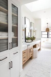 Beautiful modern master bathroom with a mix of black and brass metal finishes, double light wood vanity - pure salt