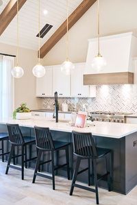 Herringbone kitchen backsplash inspiration for a modern farmhouse interior style. Pendant lighting and wood beam ceilings add height to this beautiful kitchen.