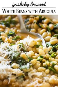 Arugula adds brightness and a peppery flavor to this simple and healthy recipe for Italian braised white beans with garlic and tomatoes. It's a satisfying side dish for all sorts of meals, especially grilled or seared lamb chops or steak. | justalittlebitofbacon.com #italianrecipes #sidedish #mediterraneandiet #beans #italianfood