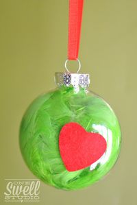 A Christmas ornament filled with green feather, what a great kid party activity! See more party ideas at CatchMyParty.com. #christmasornament #partyactivity #christmas