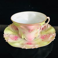 "An absolutely stunning Austrian tea cup and saucer.  It is an antique piece and in excellent condition.  It is 5 1/2\" across the saucer, that is embellished  with a very ornate pattern raised in the china.  It is also raised around the cup with a drape pattern around the bottom.  It is just absolutely perfect.  It has no damage or crazing.  Light green in the background with pink and adorned with pink roses.  The cup is 3 1/2\" across the top and 2 1/4\" tall.  Trimmed out in gold."