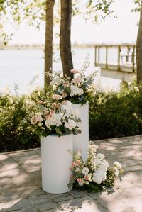 Romantic Lakeside Ceremony - Altar Decor with White Round Pillars and Whimsical Blush and Sage Floral Arrangements | Image by Bennett Murphy-Mills Photography | Flowers by Prairie Creative Florals