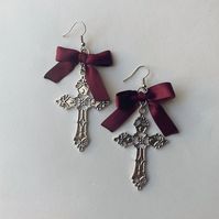 A silver hardware earring with large gothic crosses and burgundy satin bows 🖤