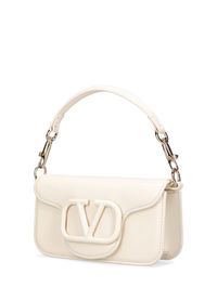 Find VALENTINO Locò Leather Top Handle Bag on Editorialist. The VALENTINO GARAVANI Locò bag is crafted from leather and features a top handle, detachable metal chain strap, flap closure, and logo detail. The bag measures 11cm in height, 20cm in width, and 5cm in depth. The strap drop measures 29/56cm and the handle drop measures 10cm. This small bag can be worn on the shoulder or hand carried. It is perfect for evening occasions.