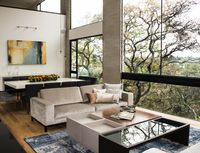 Living Room | Light beige sofas with throw pillows, blue weathered rug, lacquer and natural wood coffee table and exposed brick wall, double height ceilings, black metal frame windows, natural wood floors, black granite floor and concrete columns | Mexico City #HuacalEstudio #InteriorDesign #MadeInMexico #Mexico #Styling #Decor #LivingRoom