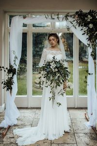 Cascading bouquet with foliage and white flowers.  White & Green ceremony arch.  Winter wedding, classic green & white wedding inspiration.  See the full supplier list on the blog, link below.