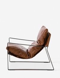 Meet your new favorite lounge chair. It features top-grain leather in a rich tobacco color, complete with a black metal frame for a quintessential mid-century look.