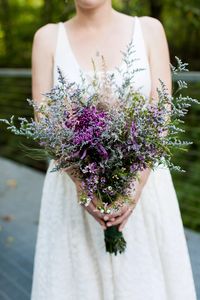 “We wanted our flowers to be evocative of the prairie in early fall—lots of purple and yellow flowers blooming among the golden grasses,” Margaret says. Her bouquet was made of purple caspia, purple spider mums, purple waxflowers, wheat and pink astilbes.