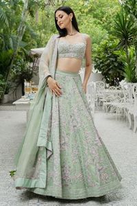 Pistachio green lehenga with bead embellishment in floral motifs and cutwork detail on the waistband. Comes with sleeveless blouse and dupatta. Components:3 Pattern:Embellishment Type of Work:Bugle Beads, Cutdana and Sequin Neckline:Sweetheart Sleeve Length:Sleeveless Fabric:Silk Organza Color:Green Other Details: Blouse with cutwork detail Dupatta with embroidered border Tie up on the side Occasion:Wedding - Aza Fashions