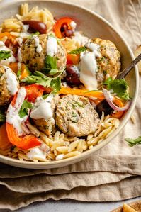 Delicious Greek turkey meatballs with lemon orzo, tender veggies, and a creamy feta yogurt sauce. These healthy baked Greek turkey meatballs are filled with tons of wonderful herbs and make the perfect protein-packed weeknight meal! #meatballs #mealprep #greekrecipe #healthydinner #orzo