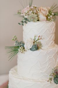 Edible and stunning! This gorgeous wedding cake incorporates the bridal floral arrangement style and color palate into its design. The blush pink roses, green eucalyptus, and pines add a unique freshness to this dessert. It's a great idea to add this small detail to your wedding day, as it is sure to wow your guests and leave you with a fond memory. This photo was taken by Juliana Tomlinson Photography at our winter wedding at Indian Valley Country Club.