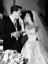 Elizabeth Taylor serves her new husband Conrad Hilton Jr cake during their wedding reception on June 5, 1960 in Los Angeles.