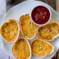 These Mexican Taco Boat Quiches are the perfect little breakfast. They're super easy to make and just delicious! The egg custard, taco seasoning, veggies and cheese are baked right in a soft flour tortilla bowl. 