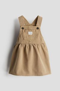 Dungaree dress in soft, cotton twill. Shoulder straps with a press-stud, open chest pocket with an appliqué, fake front pockets, a gathered seam at the waist and a gently flared skirt.