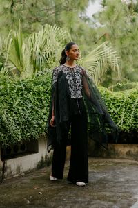 PRODUCT DETAIL: Make a bold and chic statement at your next Diwali dinner, wedding reception, or formal party with our Black Organza Embroidered Cape Set. This ensemble is a standout choice that exudes sophistication and uniqueness. The exquisite white embroidery on the neck is beautifully complemented by subtle detail