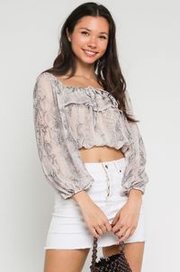 Enjoy some sunshine in the Mila Blush Snake Long Sleeve Ruffle Crop Top! This cute woven blouse has a blush snake print, rounded neckline, and long puff sleeves with cinched cuffs. Ruffle overlay on neckline with tie falls over relaxed bodice with an elasticized, cropped hem.