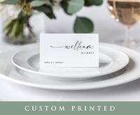 Elevate your wedding reception with our unique, printed wedding place cards that seamlessly blend modern elegance and simplicity. Each 3.5x2 tent-style card showcases the guest's first name in a sophisticated modern handwriting script, perfectly paired with a clean block font for the last name. Aligned on the left side, you'll find the table number and optional meal choice, ensuring a seamless and organized seating arrangement. These printed wedding place cards are crafted on durable 100lb cardstock, promising a polished and sturdy finish. These beautifully designed place cards not only enhance the aesthetics of your wedding but also provide a practical solution for guiding guests to their seats. Make your special day unforgettable with these stylish and functional place cards that add a t