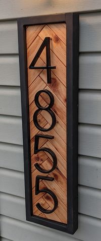 "VERTICAL HERRINGBONE ADDRESS SIGN -5\" or 6\" tall floating metal numbers. -Built with all-natural weather resistant cedar.  -Frames are painted with exterior grade black paint. -The herringbone cedar insert is finished with exterior grade, all natural Walrus Pure Tung Oil   to preserve the natural beauty of the cedar. -Each plaque includes two vinyl siding hangers or two D ring hangers for attaching your address sign to any other siding. Please note in \"Add Personalization\" box which type of