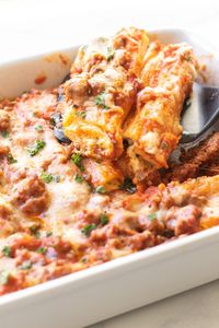 Cheesy Baked Manicotti is a hearty dinner that you can make ahead! Manicotti pasta shells are stuffed with a four-cheese filling, topped with a savory meat sauce and cheese, and baked until bubbling hot. The best part? You don't have to boil the pasta first! It makes the prep so much easier.