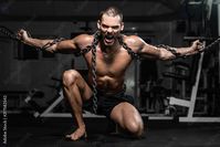 Muscular man slave in chains in gym, the prisoner Stock Photo