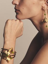 Reinterpreted as exquisite jewellery pieces, the Antinea green shiny crystal beads are delicately placed upon gold-plated Ginkgo leaves, wavy and finely chiseled.