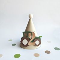 Looking for Boy Birthday party hat?! This eye-catching, stylish Tractor party hat is perfect idea for fun and amazing photos. A great idea for boy cake smash! Designed to matching Tractor theme or Farm Birthday.--COLOR--• Green, Tan, White, Brown, Sand -- DETAILS--• Made of high quality design paper• Tractor Birthday Party hat designed with cute tractor and number "2" in front• Decorated with pom pom on the top• Size: height: 5.5" (14 cm) & width: 3.5" (9 cm) at widest point• Farm theme party ha