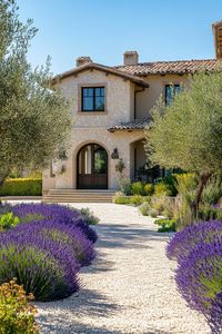 Modern Italian mediterranean house frontyard veggie garden with lavender lining and olive trees. Check out all of these stunning Italian Mediterranean houses that encapsulate elegant arches, textured stucco, charming terra cotta details, and so much more.