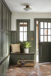 The contrast of the green cabinets and tile floors adds depth and character to this entry and mudroom space