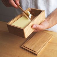 山桜をくりぬいて作ったバターケースです。木のバターケースは内部が冷えすぎず、バターが固まりにくいという特徴があります。また、蓋を含めてひとつの木の塊からくり抜いて作られているので継ぎ目が一切なく、接着剤�などを使用しておりませんので安全で一生使って頂ける丈夫なつくりになっています。山桜は使い込むほどに色に深みを増す良材です。経年による道具の成長も楽しんで頂ければと思います。※冷蔵庫内温度変化に耐えるため木固めエース（食品衛生法許可 学校給食器などにも使われる）で木内部を強化しております。＜お取り扱いについて＞頻繁に洗うことは無いかとおもいますが、普通に水洗いして頂けます。（漬け洗い、食洗機、電子レンジでのご使用はできません）洗い後は直射日光の当たらない風通しの良い場所で乾燥させてから保管して下さい。経年によるカサつきが気になるようでしたら、「えごま油」または「クルミ油」を塗り直射日光の当たらない場所で乾燥させて下さい。蜜蝋クリームをお持ちでしたら薄く塗り込むことでさらに撥水性が高まります。＜サイズなど＞ケース 約W150 D85 ...