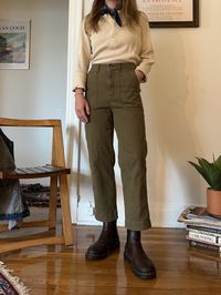 Unlabeled green military pants. Long pockets in front, striped design in fabric, zip fly enclosure, adjustable waistband in back.  Fits like a modern 26/27  Waist:  13.5 inches across  Hips:  18.5 inches across  Rise: 12 inches  Inseam:  24.5 inches