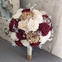 Bouquet with sola wood flowers in burgundy, natural, and ivory, with baby's breath. Flower styles can and will vary based on current inventory levels and to keep orders unique, so they are not exact duplicates. Size pictured is a large (approximately 9" in diameter).