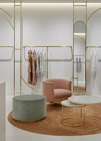 Curved polished brass racks run in arches and bends throughout the Alice McCall store in Westfield Miranda, Sydney. Designed by Studio Wonder.