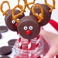 Chocolate Covered Oreo Reindeer Cookies are an adorable Holiday treat for kids and big kids alike. Double stuffed Oreos dipped in melted chocolate, pretzel antlers, candy eyes, and red hot nose -they come alive as the face of reindeer to spread Holiday cheer. #christmastreats #oreo #reindeer #christmasfood #easydessert #dessert #christmas #rudolph #nobake #holidayparty #christmasparty