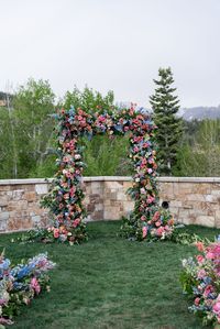 Coral garden rose, coral dahlia, pink peony, blue delphinium, blush spray rose, green hydrangea, pink coral snapdragons, peach coral ranunculus, poppies - ceremony arch flowers